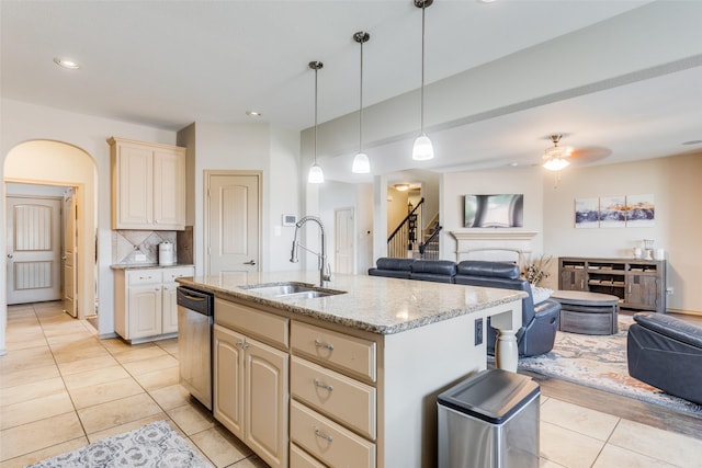 kitchen with pendant lighting, tasteful backsplash, an island with sink, sink, and stainless steel dishwasher