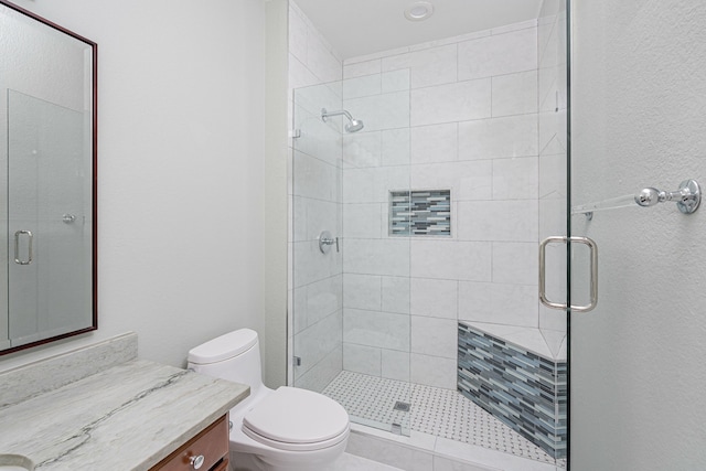 bathroom with vanity, a shower with shower door, and toilet