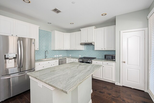 kitchen with white cabinetry, gas stove, dark wood-type flooring, and decorative backsplash