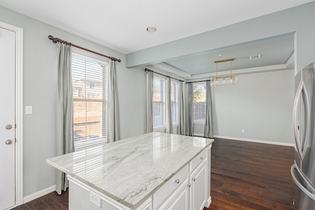 kitchen featuring pendant lighting, stainless steel fridge, white cabinetry, dark hardwood / wood-style floors, and a kitchen island