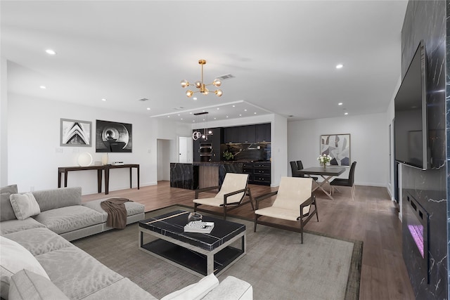 living room with wood-type flooring and an inviting chandelier