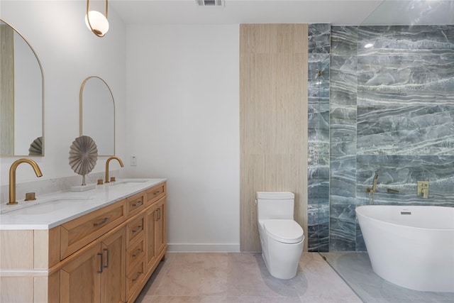 bathroom with tile patterned flooring, vanity, a bathtub, and toilet