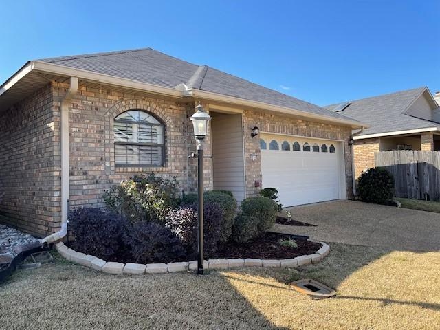 ranch-style house with a garage and a front lawn