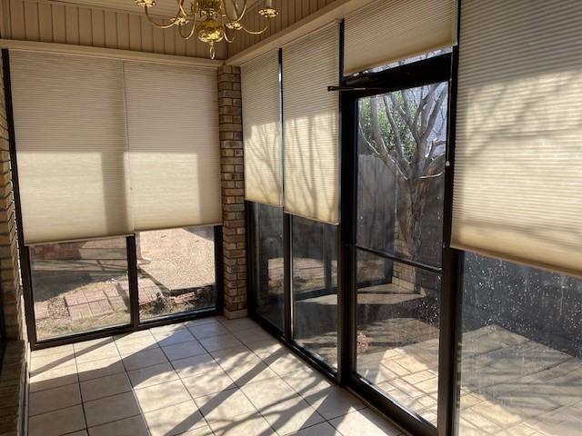 unfurnished sunroom with a notable chandelier