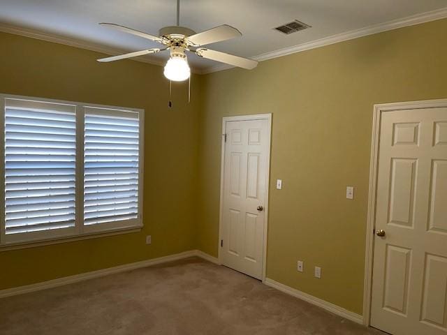 unfurnished bedroom with ceiling fan, light colored carpet, and ornamental molding