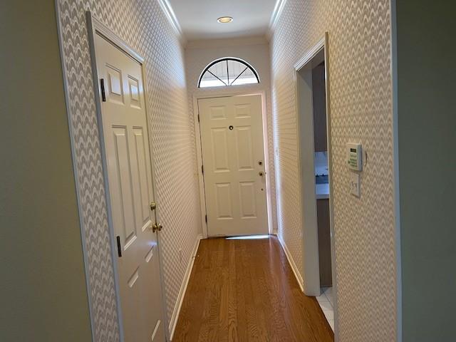 doorway featuring ornamental molding and dark hardwood / wood-style floors