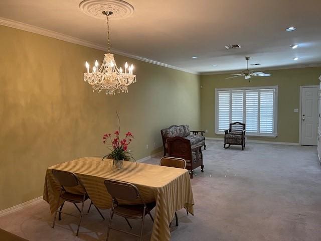 dining space featuring crown molding, ceiling fan with notable chandelier, and light carpet