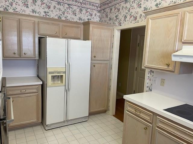 kitchen with black electric stovetop and white refrigerator with ice dispenser