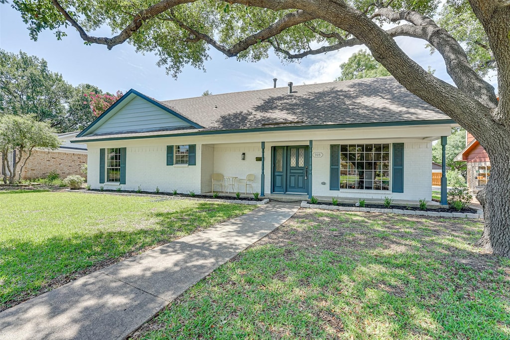 ranch-style home with covered porch and a front lawn