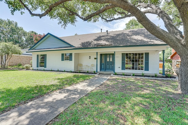 ranch-style home with covered porch and a front lawn