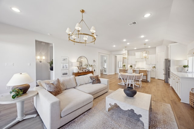 living room with a chandelier and light wood-type flooring