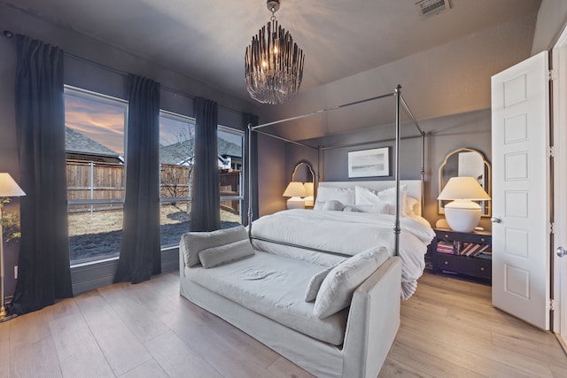 bedroom featuring a notable chandelier and light hardwood / wood-style flooring