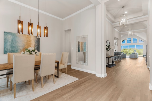 dining space featuring crown molding, a towering ceiling, hardwood / wood-style floors, and a chandelier