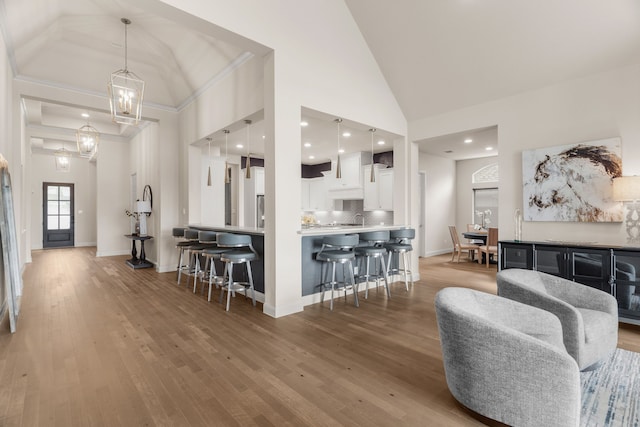 kitchen featuring hanging light fixtures, white cabinetry, a breakfast bar, and hardwood / wood-style floors