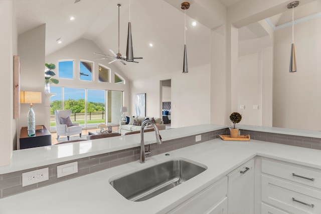 kitchen featuring pendant lighting, ceiling fan, sink, and white cabinets