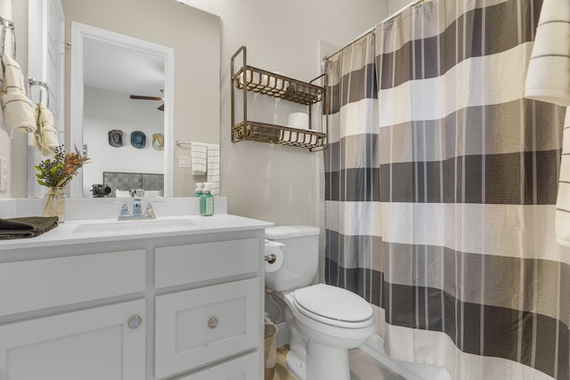 bathroom featuring vanity, ceiling fan, curtained shower, and toilet