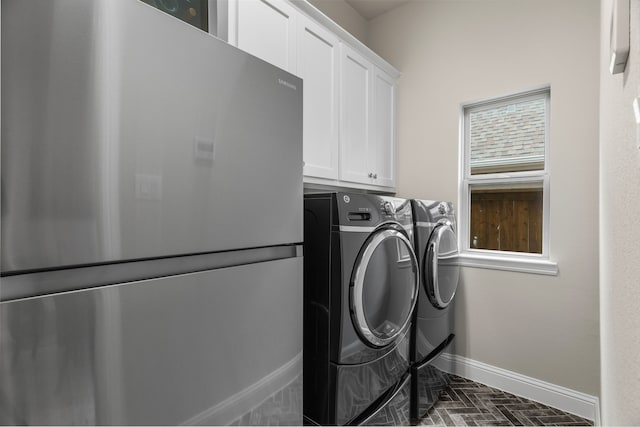 laundry room featuring cabinets and washer and clothes dryer