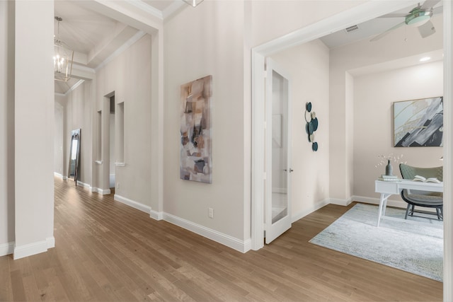 hallway featuring hardwood / wood-style floors, a notable chandelier, and ornamental molding