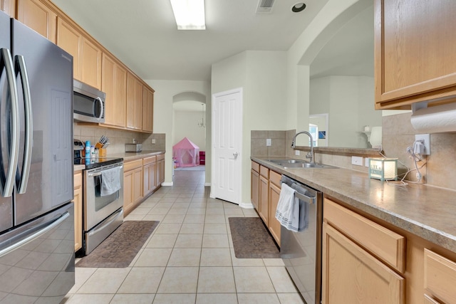 kitchen featuring sink, light tile patterned flooring, stainless steel appliances, and light brown cabinets