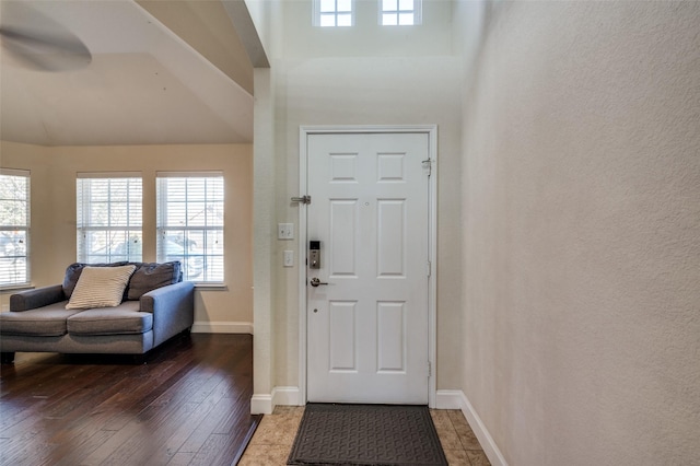 foyer featuring a towering ceiling and dark hardwood / wood-style flooring