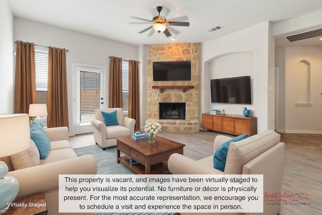 living room with ceiling fan, a wealth of natural light, a fireplace, and light hardwood / wood-style floors