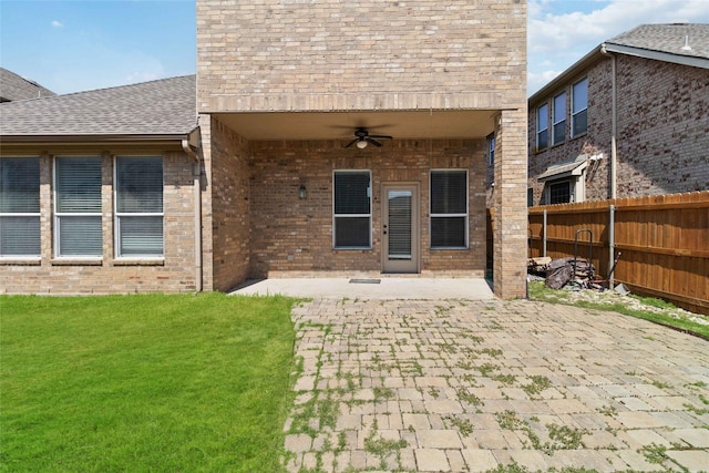 rear view of property with a yard, ceiling fan, and a patio area