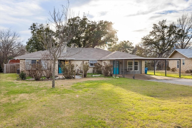 rear view of property with a carport and a yard