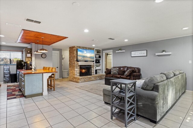 kitchen with butcher block counters, a breakfast bar area, wood ceiling, green cabinets, and stainless steel appliances