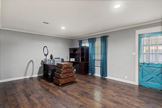 bedroom with dark wood-type flooring, crown molding, and a closet