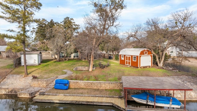 dock area with a water view and a lawn