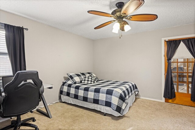 carpeted bedroom with ceiling fan and a textured ceiling