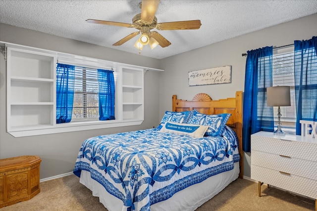 bedroom featuring ceiling fan, carpet, and a textured ceiling