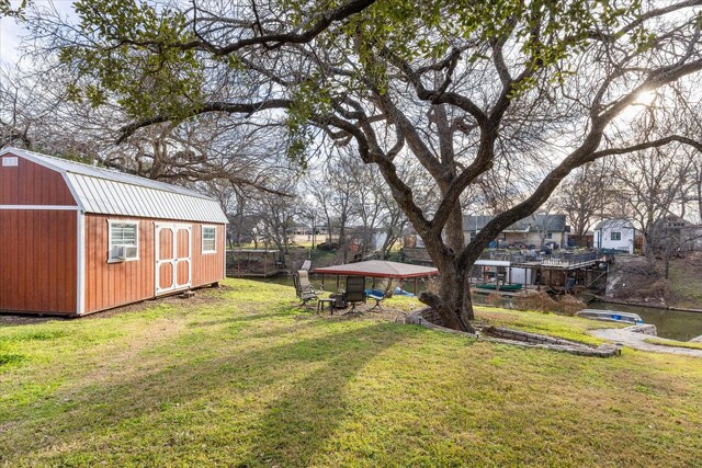 view of outbuilding with cooling unit and a lawn