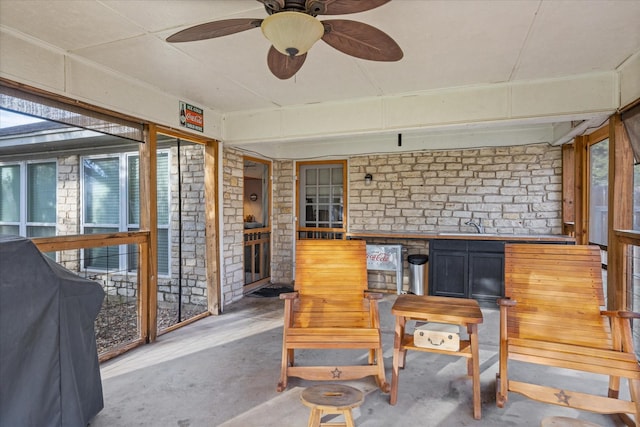 sunroom / solarium featuring ceiling fan