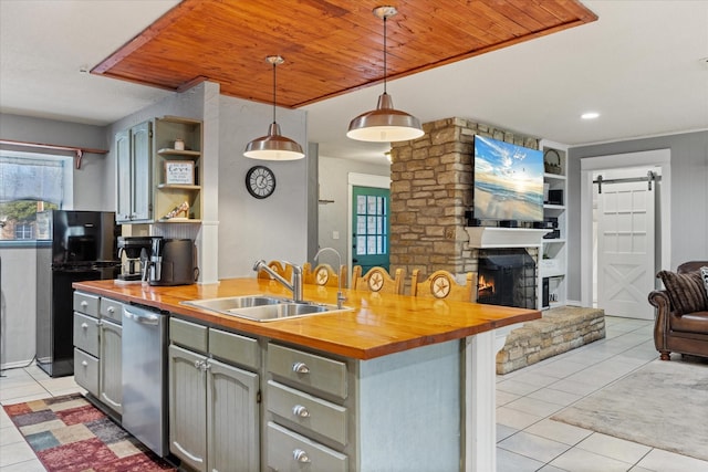 kitchen with light tile patterned floors, sink, wooden counters, dishwasher, and hanging light fixtures