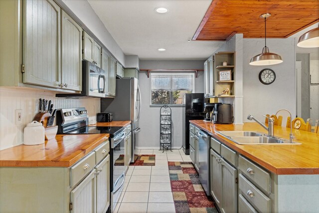 living room with a stone fireplace, sink, light tile patterned floors, and built in features