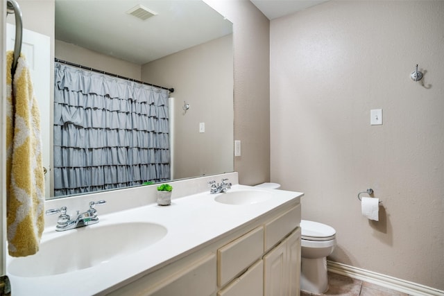 bathroom featuring vanity, tile patterned flooring, and toilet