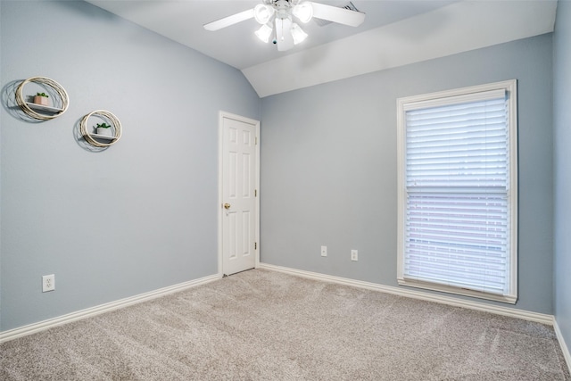 carpeted empty room with vaulted ceiling and ceiling fan