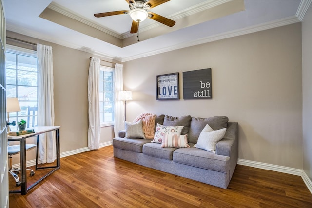 living room with hardwood / wood-style flooring, ornamental molding, and a raised ceiling