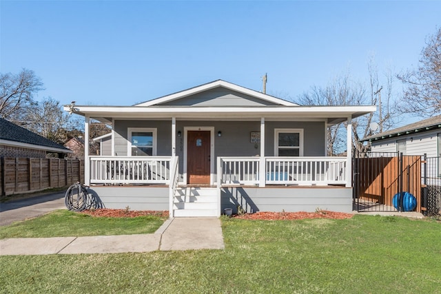 bungalow with covered porch and a front lawn