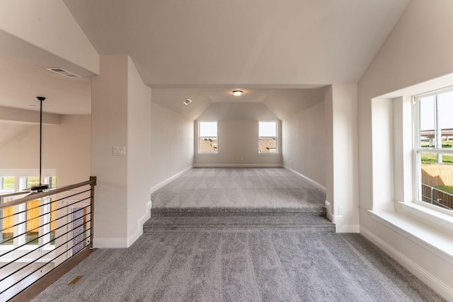 corridor with light colored carpet and lofted ceiling