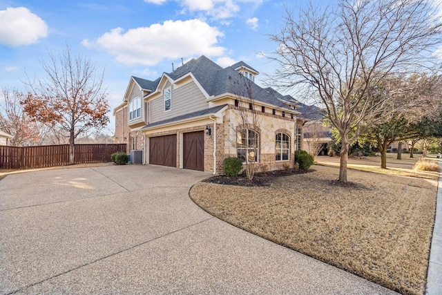 view of side of property featuring central AC unit and a garage