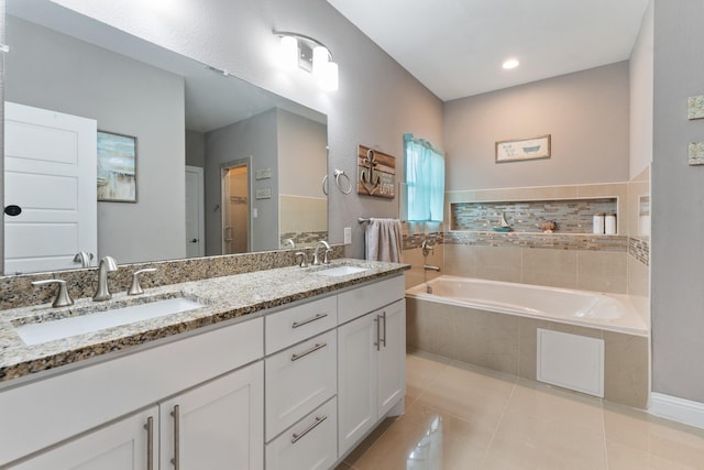 bathroom with vanity, tiled bath, and tile patterned flooring