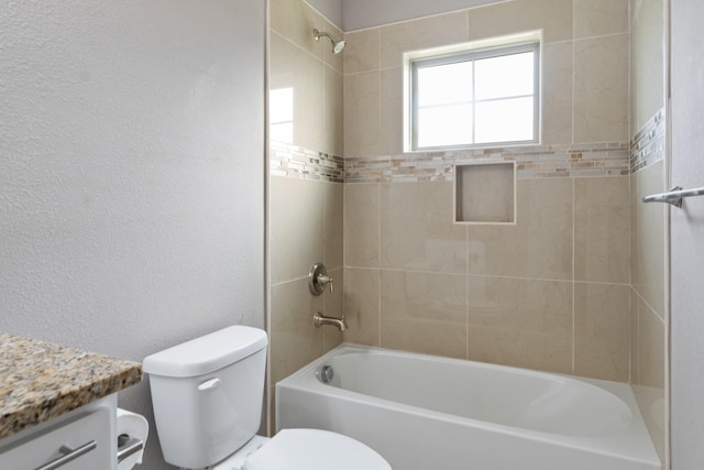 full bathroom with tiled shower / bath, vanity, and toilet