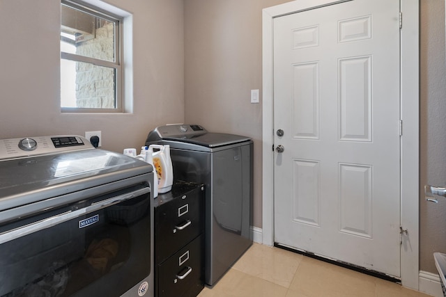 laundry room with separate washer and dryer and light tile patterned floors