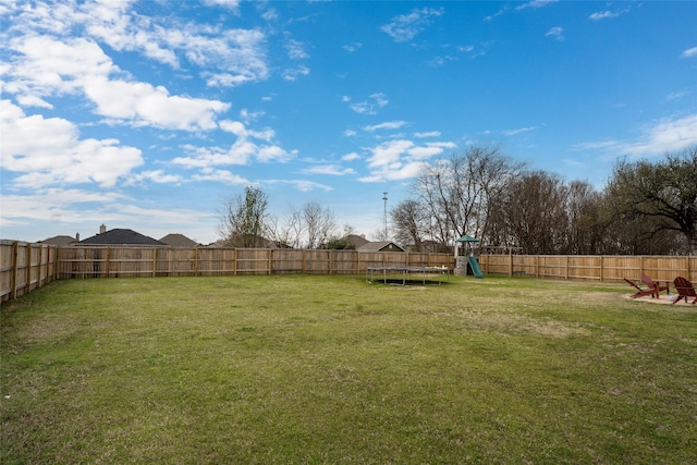 view of yard with a playground and a trampoline