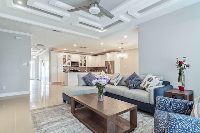 living room with coffered ceiling, ceiling fan with notable chandelier, beam ceiling, and light tile patterned floors