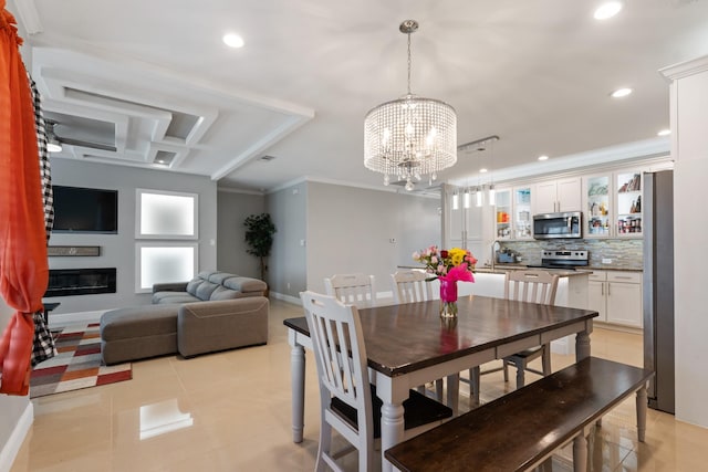 tiled dining space featuring ornamental molding, sink, and a chandelier