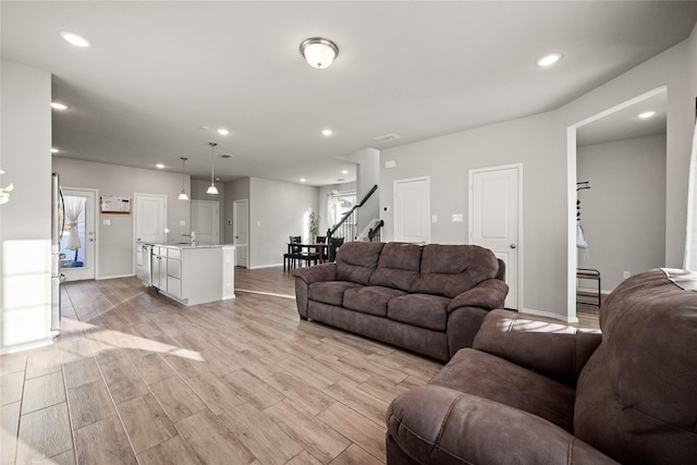 living room featuring sink, a wealth of natural light, and light hardwood / wood-style flooring