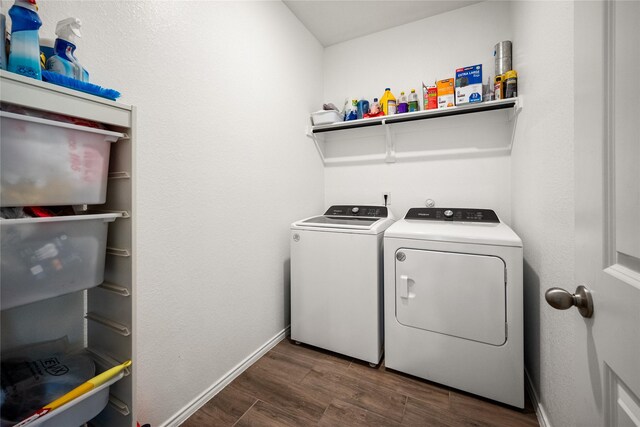 laundry area with dark hardwood / wood-style flooring and washing machine and clothes dryer